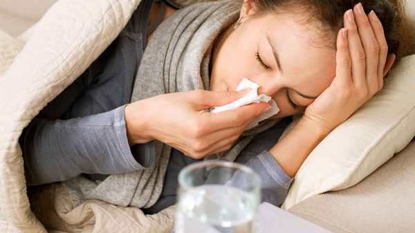 woman with colds wiping nose with white tissue