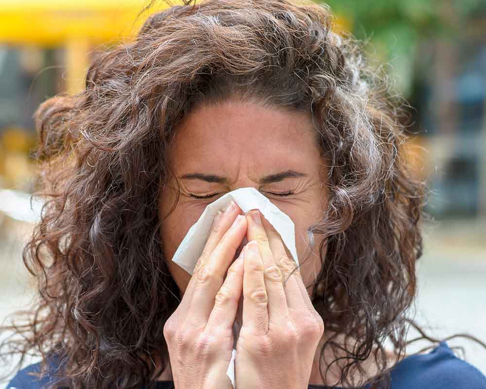 woman sneezing due to allergy