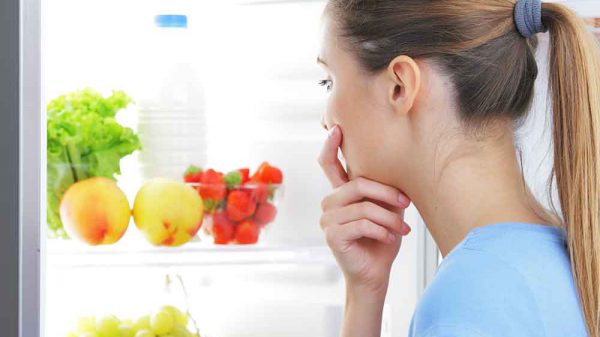 woman looking inside the fridge craving for something to eat
