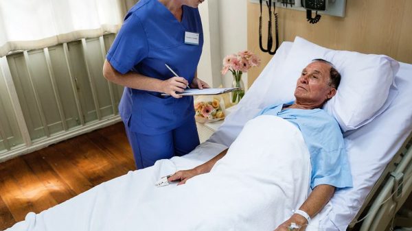 old male patient lying on a hospital bed being checked by a doctor