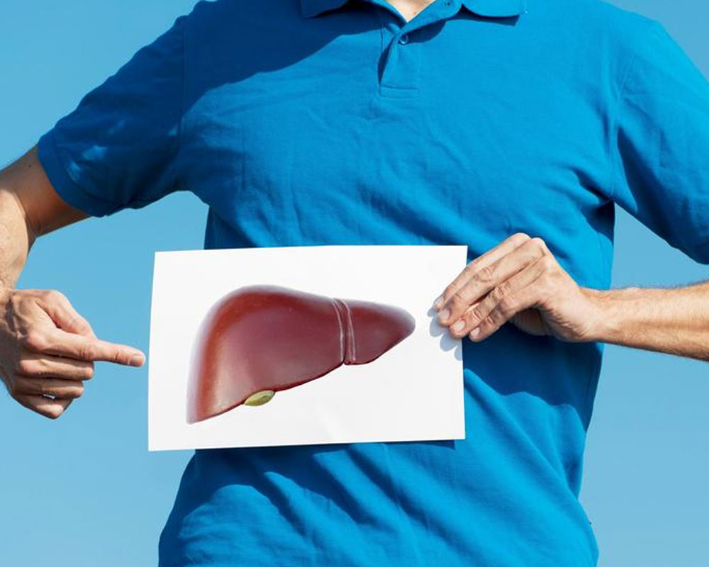 Man wearing blue shirt holding a picture of liver