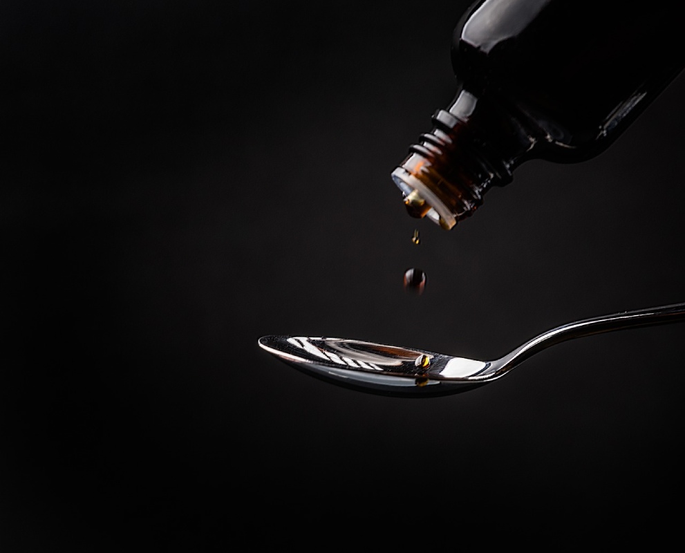 Lactulose pouring on a silver spoon