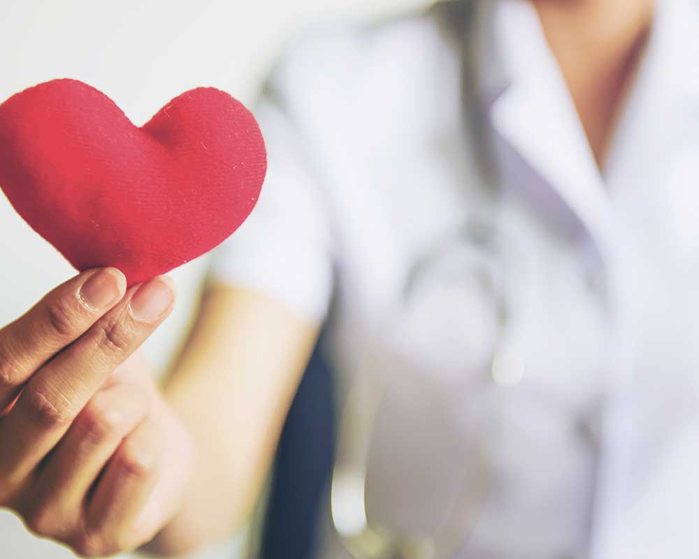 Nursing holding a small heart plush