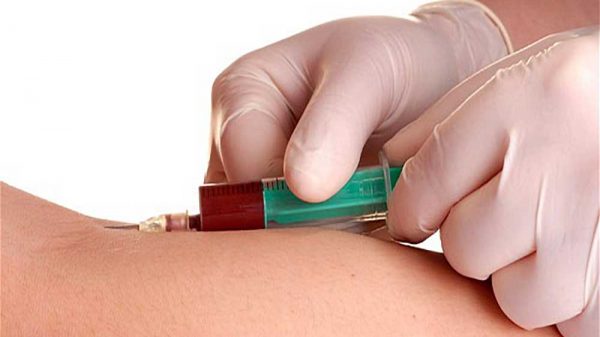 syringe inserted on skin for blood sample