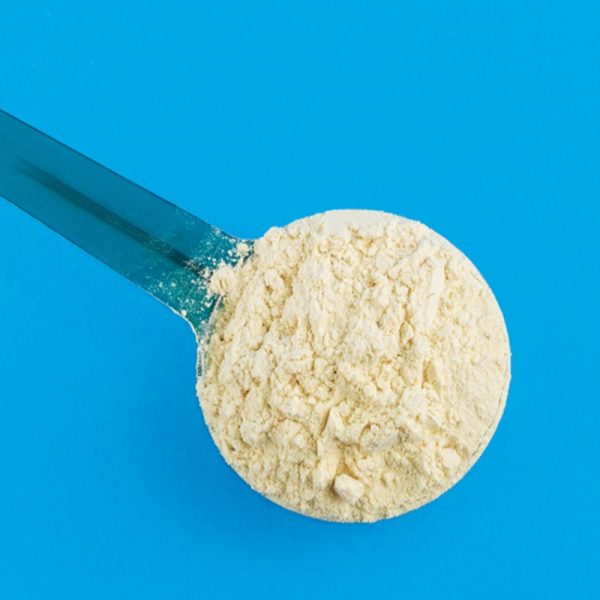 a scoop of amino acid powder blue background