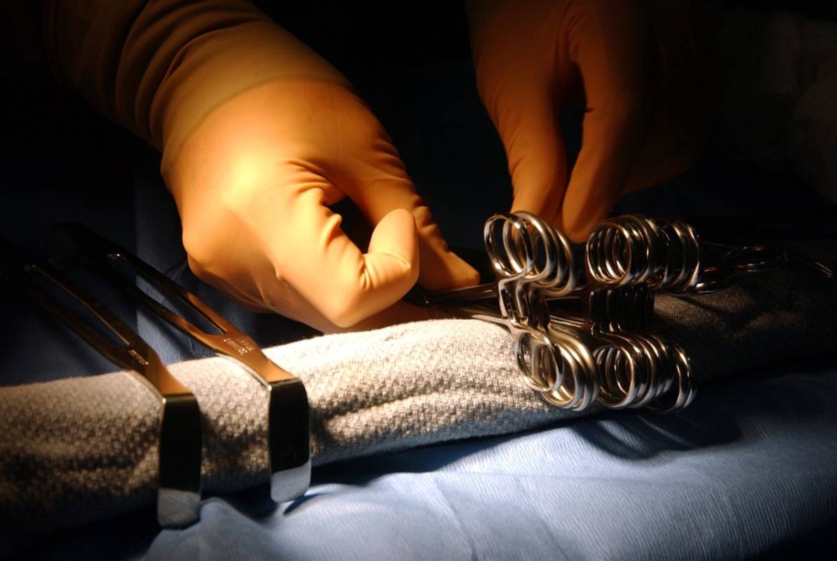 hands preparing surgical instrument for Orthotopic Liver Transplant