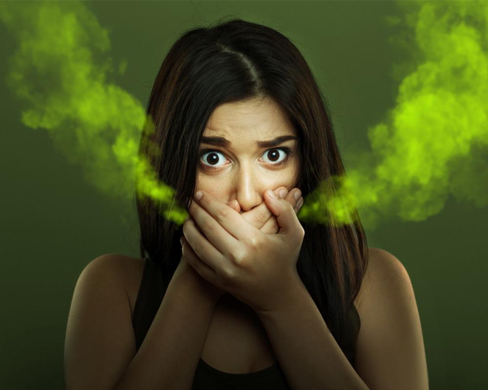 Woman with bad breath covering mouth
