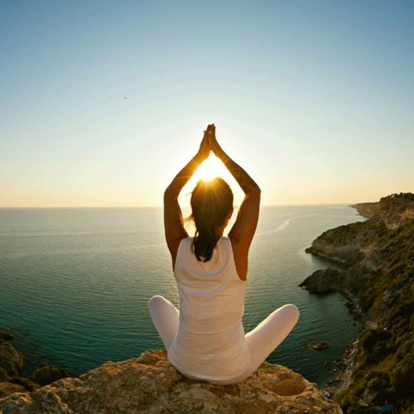 girl doing yoga pose with sunset background