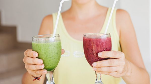 Woman holding two glasses of smoothies