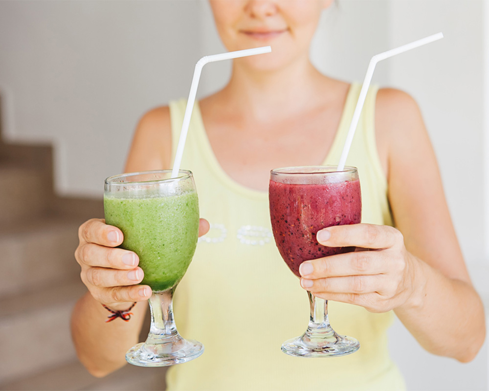 Woman holding two glasses of smoothies